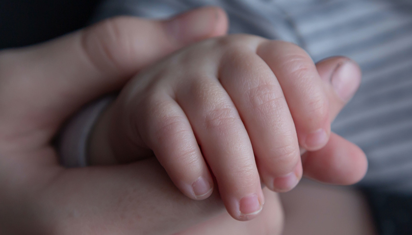 Baby hand in adult hand