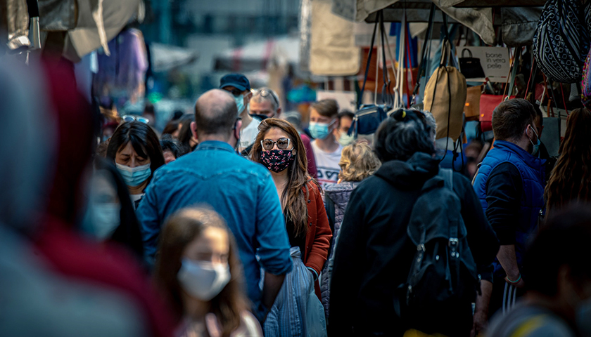 Crowded street market with people wearing masks