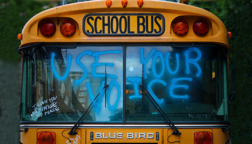 School bus with "use your voice" on the windshield