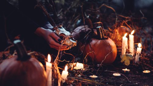 Person decorating with candles and pumpkins
