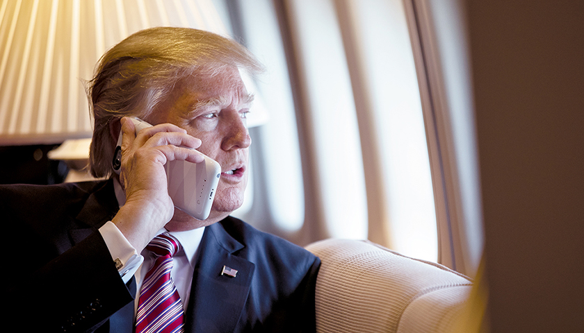 President Donald Trump talks on the phone aboard Air Force One during a flight to Philadelphia, Pennsylvania, to address a joint gathering of House and Senate Republicans, Thursday, January 26, 2017. This was the President’s first trip aboard Air Force One. (Official White House Photo by Shealah Craighead)