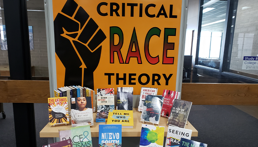 Critical Race Theory sign with a table of books